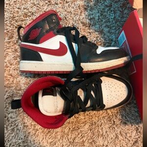 Nike Air Jordan 1 Mid in a black, white, and red colorway.